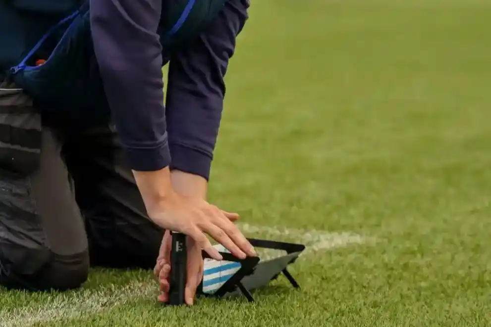 A Sports Labs specialist does testing on a sports field.
